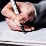 Hand writing on a notebook with pen for word count.