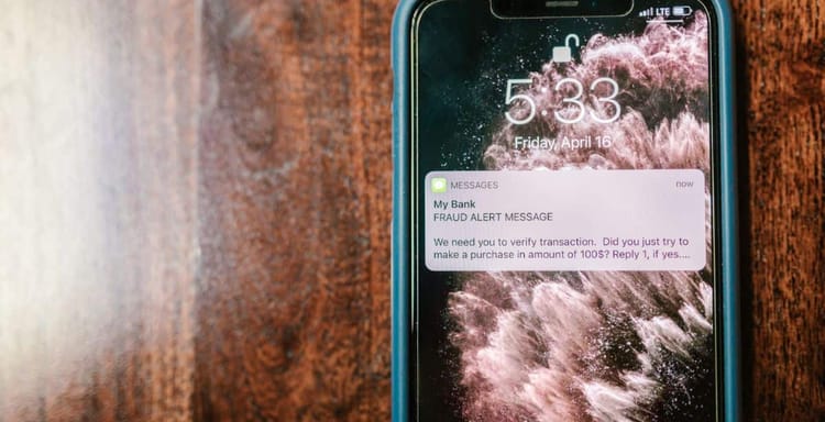 Alert message about transaction verification from bank on mobile phone.