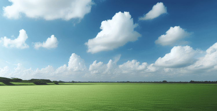 Peaceful woman resting outdoors on lush green grass with blue sky and clouds in the background.