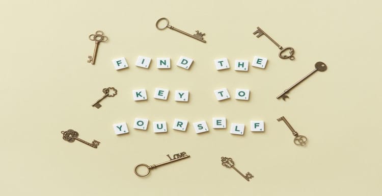 Keys and letter tiles spelling "Find the key to yourself" on a beige background.