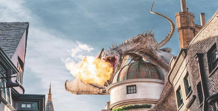 A giant dragon breathes fire atop a building in a cityscape scene.