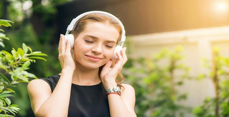 Women listening to music outdoors for relaxation.