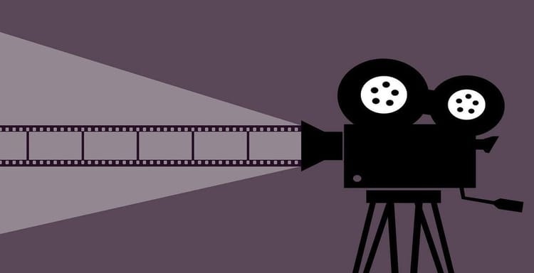 Alt text: Vintage film camera projecting light onto a film strip.