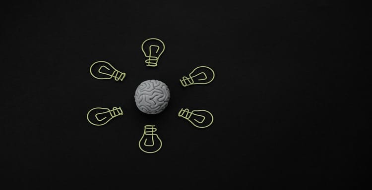 Alt text: Brain with surrounding lightbulb illustrations symbolizing ideas and creativity.