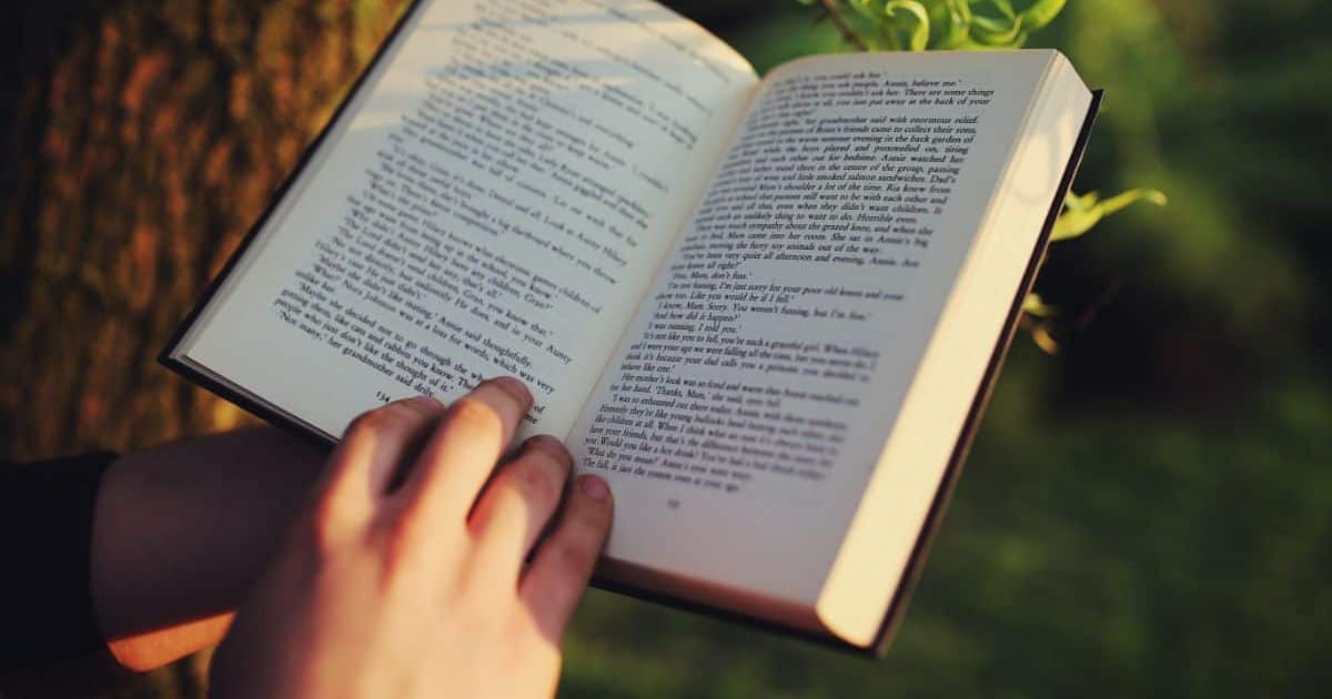 Open book with text, outdoor reading, writing, essay, story, note-taking, literacy, education, study, self-improvement.