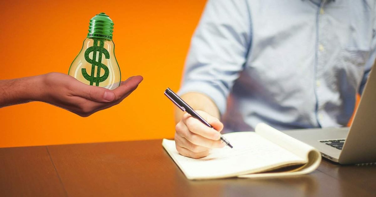 Image of hands exchanging a money-saving icon shaped as a lightbulb with a dollar sign, with a person taking notes and a laptop.