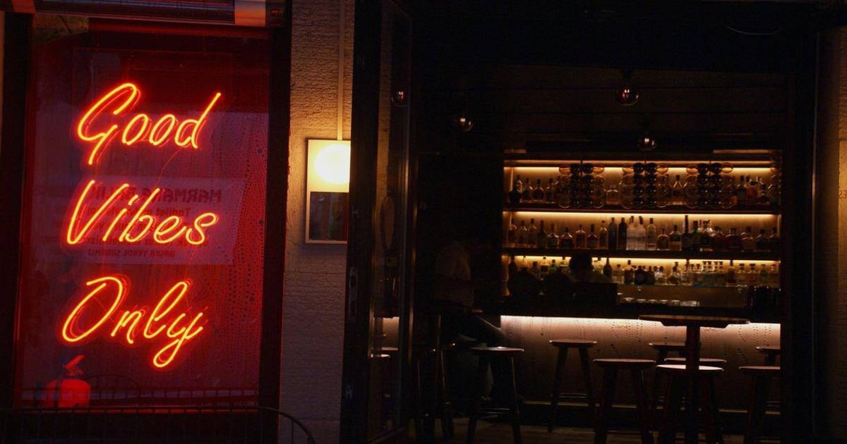 Neon sign "Good Vibes Only" at bar.