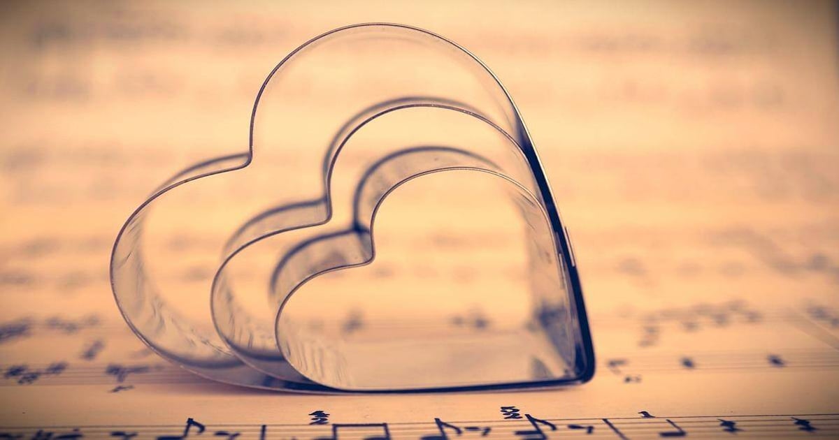 Love-themed cookie cutters placed on sheet music for baking and music lovers.
