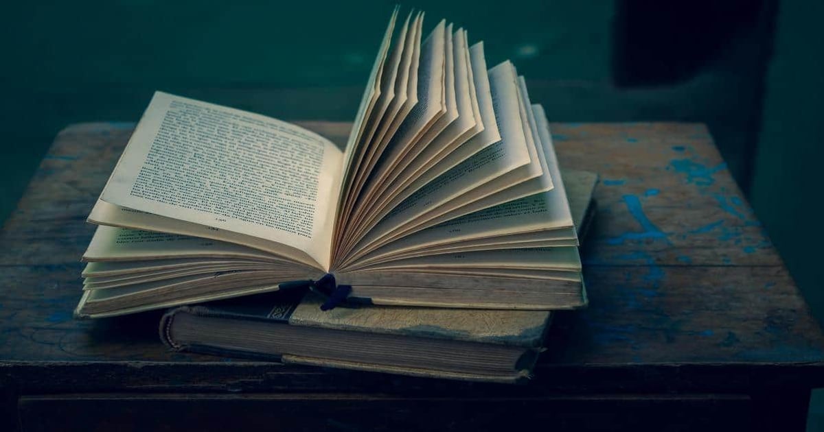 Open book with text on pages, on a rustic wooden table. Focus on writing, reading, text analysis.