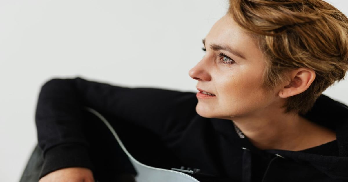 Close-up of a young woman with short hair reading and using a guitar, emphasizing writing and word counting tools.