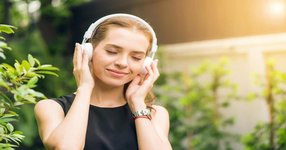 Women listening to music outdoors for relaxation.