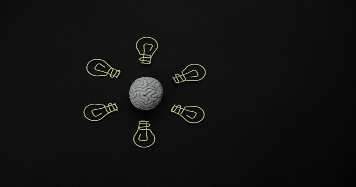 Alt text: Brain with surrounding lightbulb illustrations symbolizing ideas and creativity.