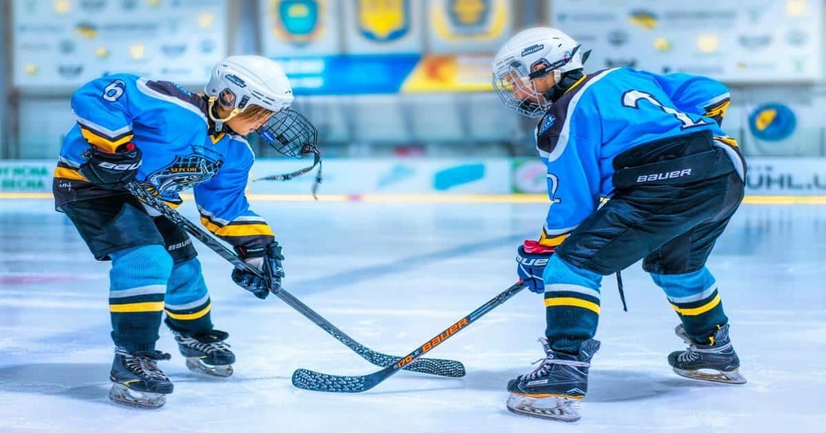 Young hockey players battling for puck.
